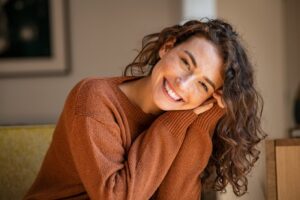 Woman tilting head and smiling with flawless teeth